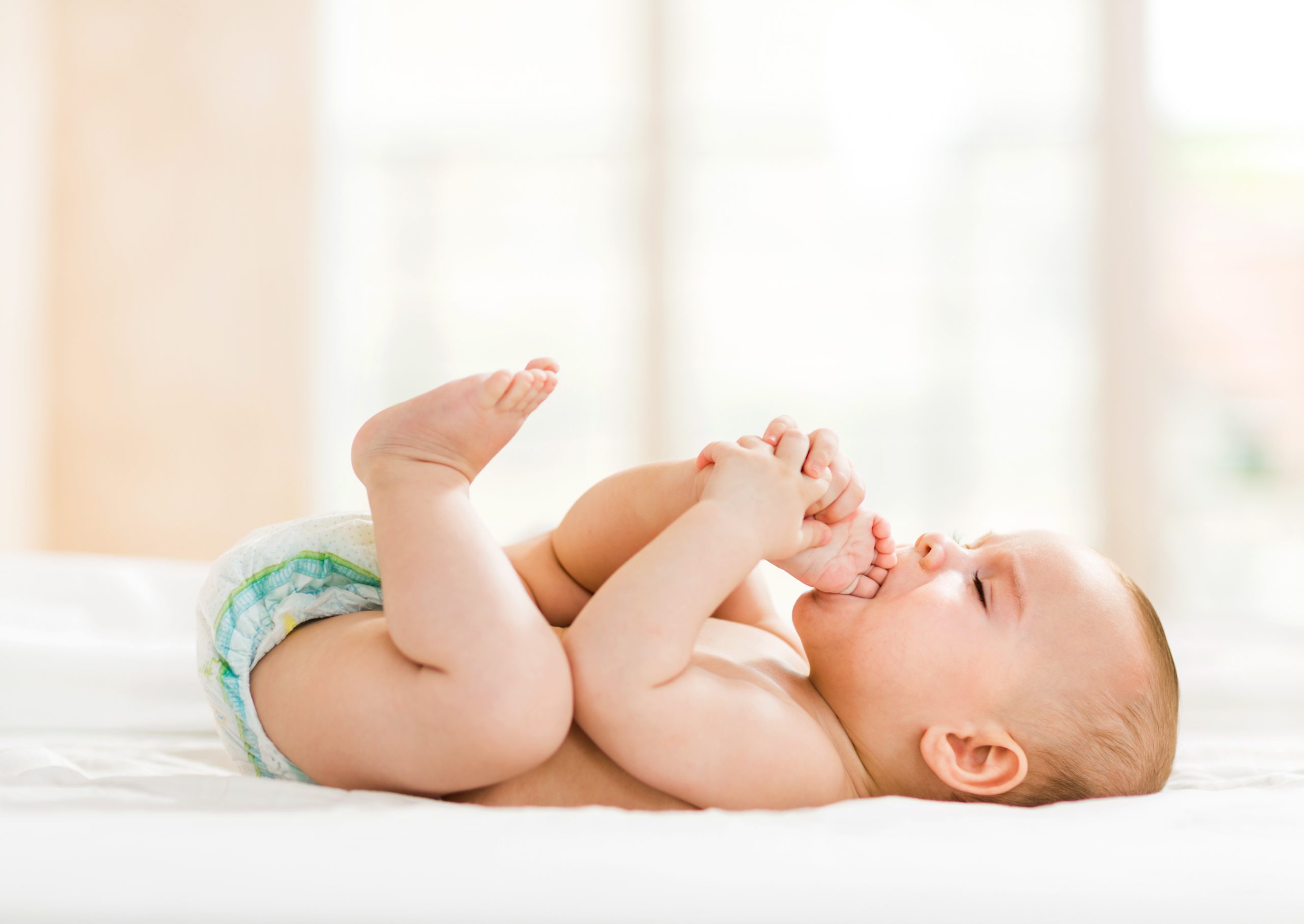 Baby liegt auf dem Bett